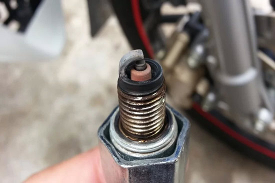 Replace motorcycle spark plugs 